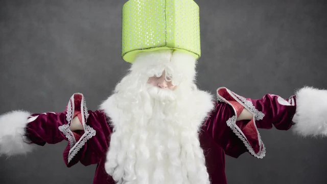 Santa Claus holding a gift on his head