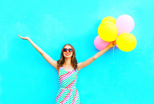 Happy Smiling Woman And An Air Colorful Balloons Is Having Fun On A Blue Background