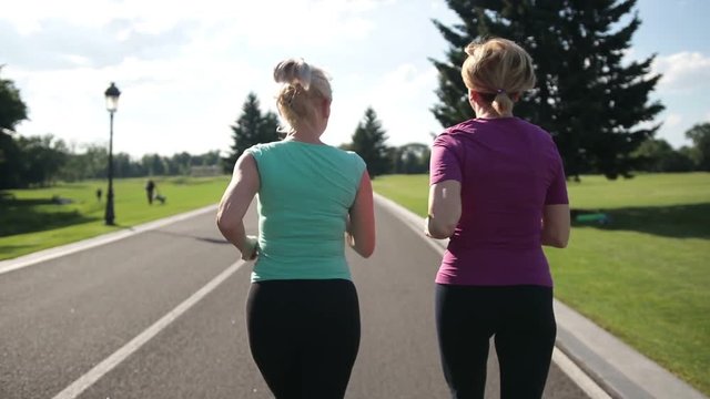 Back view of senior fitness women running on road