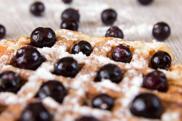 Belgian waffles with berries sprinkled with powdered sugar