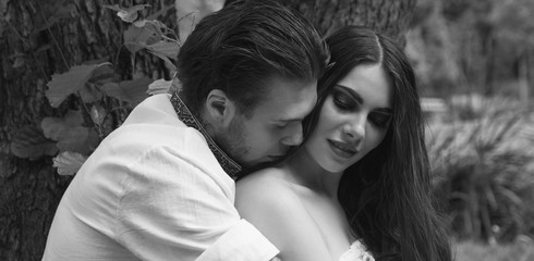 Couple in love. Guy hugs girl in the forest.