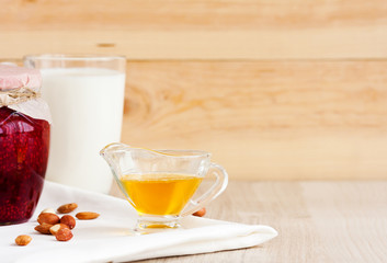 Honey, raspberry jam, milk, towel on rustic background. Candied fruits on a towel. Healthy food. Breakfast. White napkin on the table. The background. Frame
