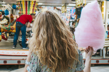 girl with cotton candy in amusement park