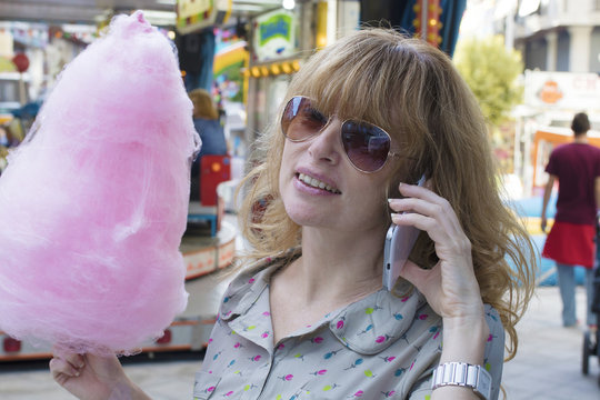 girl with cotton candy in amusement park