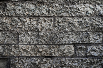Pattern of decorative grey color rough stone wall background texture
