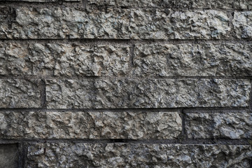 Pattern of decorative grey color rough stone wall background texture
