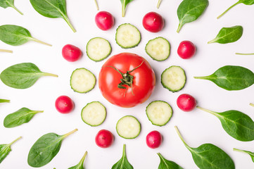 Ingredients for vegetable salad. Pattern made of spinach, tomato and cucumber on white background. Creative food concept. Flat lay, top view