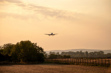 Fototapeta na wymiar Landing large airliner at sunset (Brno Airport, Czech Republic)