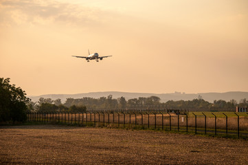 Fototapeta na wymiar Landing large airliner at sunset (Brno Airport, Czech Republic)