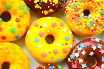 Donuts on a white background. Rainbow dots decoration. Brown sugar. Lemon, melon, pineapple, mango, banana flavour