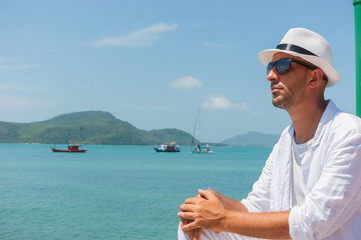 A young man sits on the waterfront