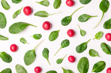 Pattern of spinach and vegetables isolated. Spinach leaves and radish on white background. Creative food concept. Ingredient for salad. Flat lay, top view