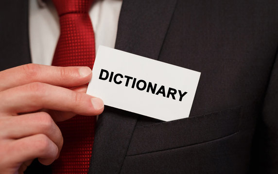 Businessman putting a card with text Dictionary in the pocket