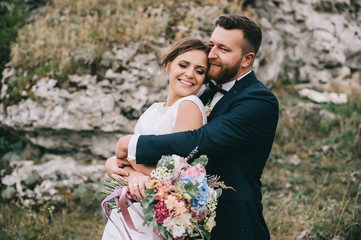 portrait of a girl and couples looking for a wedding dress, a pink dress flying with a wreath of flowers on her head on a background tsvetu chicago garden and the blue sky, and they hug and pose