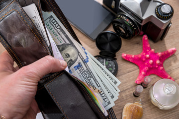 travel concept - old camera, dollar bills, compass, seashell, phone.