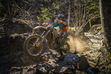 Motocross rider passes through the mud on the hardenduro race