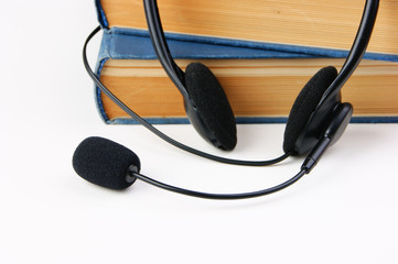 Headphones with a microphone and a stack of books