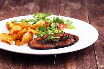 Grilled steaks, baked potatoes and salad