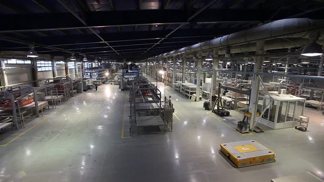 Autonomous mobile robots transport products in a large modern factory. Production of ceramic tiles, modern factory interior, Electrical Automated Guided Vehicles Platform