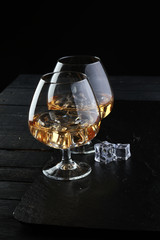 glass of whiskey with ice on a wooden