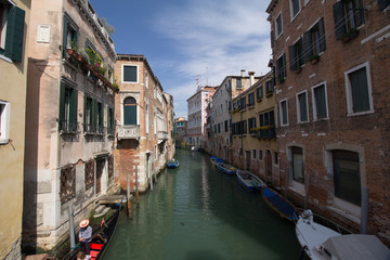 Fototapeta na wymiar Old buildings in a Venice canal with boats parking along the buildings