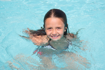 happy little girl in the pool water during the summer holidays