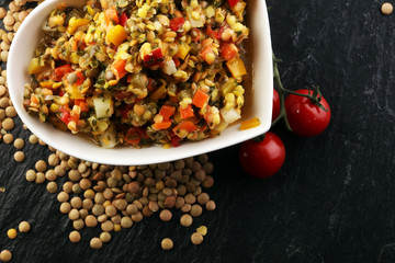 Lentil with carrot and pumpkin ragout in a wooden bowl on a wooden background
