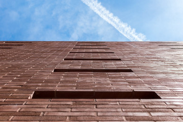 Red brick wall on blue sky with light trails