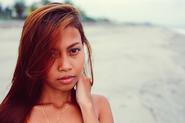 Young beautiful girl portrait on the beach