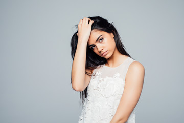 Naklejka premium Young brunette lady in dress posing on grey background