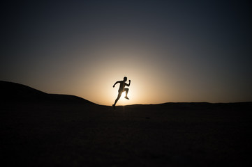 Fototapeta na wymiar silhouette or man runner, guy running outdoor at clear sky
