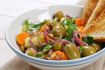 vegetable salad with pickled olives and toast