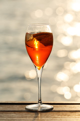 Aperol spritz at a wooden pier at sunset. Luxury resort vacation concept. Festive relax getaway background.