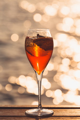Aperol spritz at a wooden pier at sunset. Luxury resort vacation concept. Festive relax getaway background.