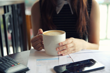 A business woman hand with coffee and business paper