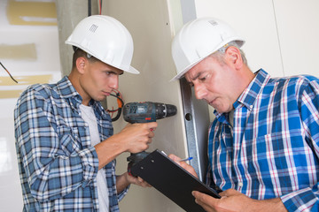 man drilling the wall with impact drill