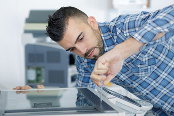 man fixing photocopying machine
