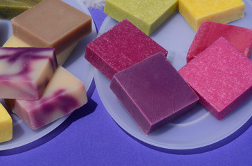 Colorful handmade beeswax soap squares on plates
