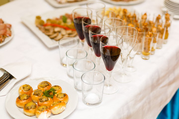 Glasses with red wine, juice and champagne on a serving table at a buffet table