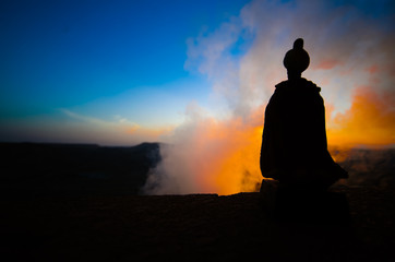 Silhouette of Arab man stands alone in the desert and watching the sunset with clouds of fog. Eastern Fairytale