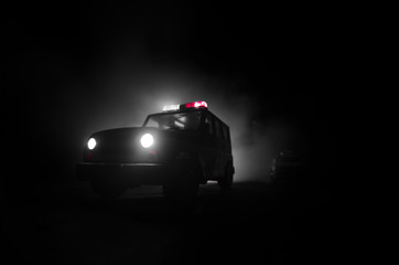speed lighting of police car in the night on the road. Police cars on road moving with fog. Selective focus. Chase