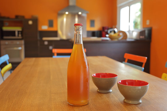 bouteille de cidre en verre avec deux bol&eacute;es dans cuisine
