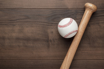 closeup of baseball bat and ball on wooden table with copy space