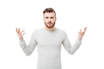 Fototapeta premium Embarrassed and confused young man showing why hand gesture over white background