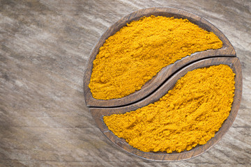 Turmeric powder on the wooden background - Curcuma longa