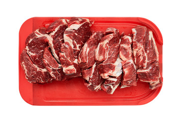 Raw beef steaks on red kitchen cutting board isolated over white background