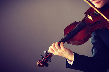 Man man dressed elegantly playing violin © Voyagerix