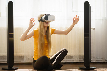 Girl wearing virtual reality goggles at home