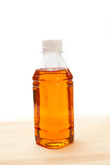 A bottle of maple syrup on a white background.