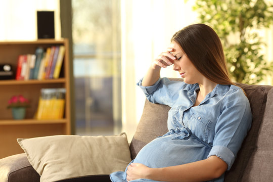 Worried pregnant woman at home